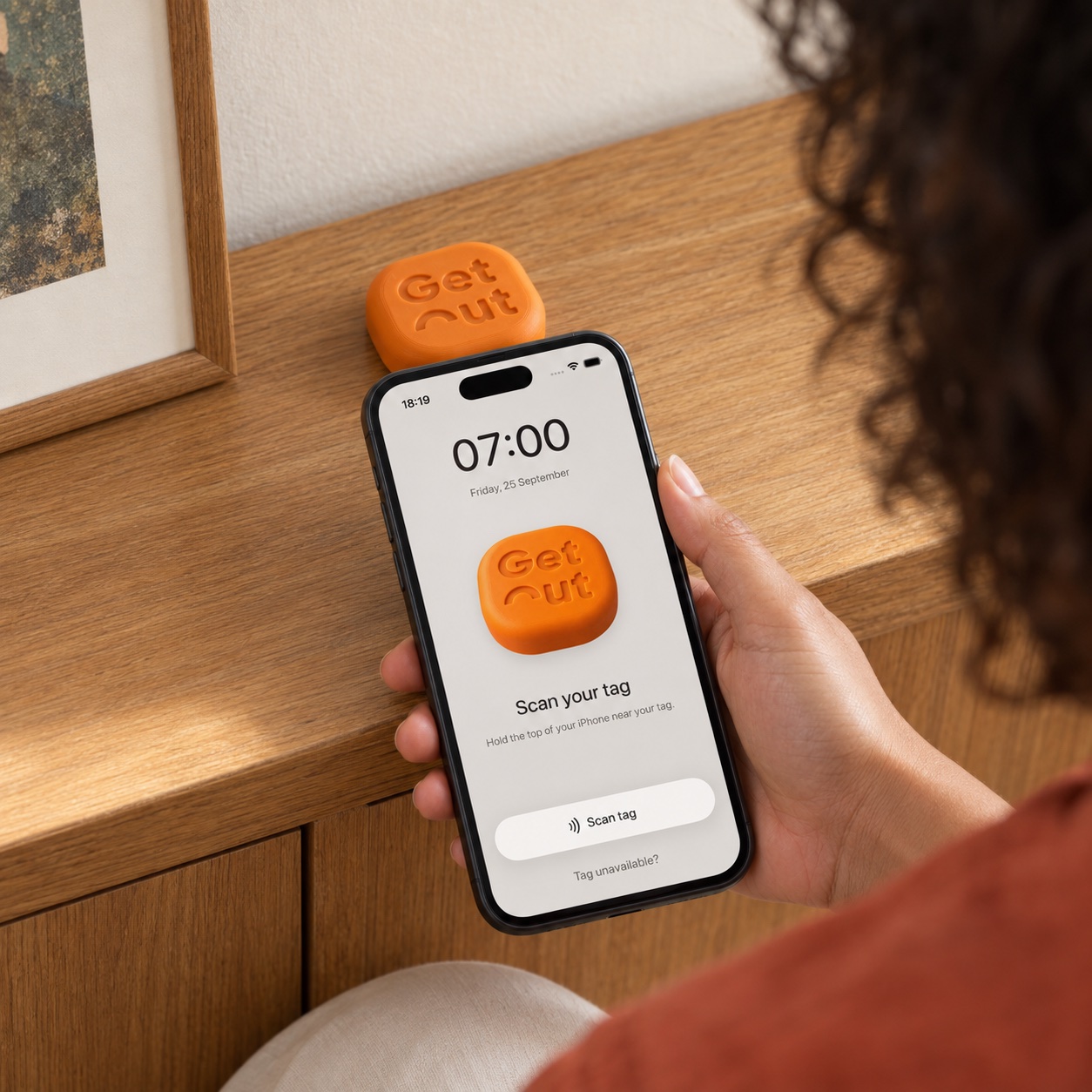 Een iPhone die dicht bij de oranje GetOut-puck wordt gehouden